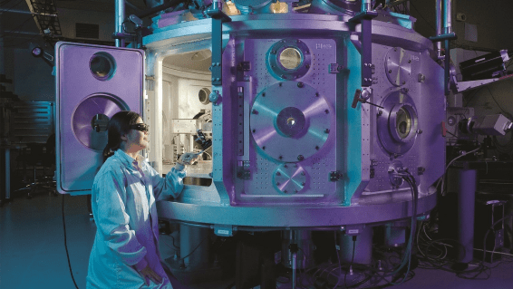 Researcher operating a large, complex scientific apparatus in a laboratory setting.